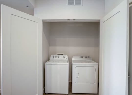 an empty laundry room with two washes and a dryer