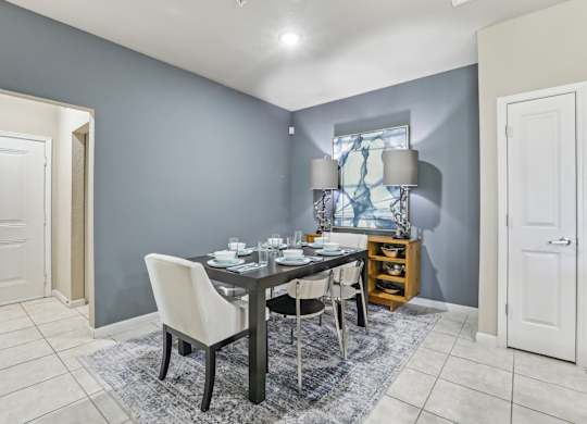 Model dining area with table near a blue wall.