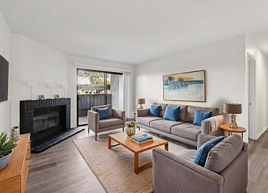A living room with a fireplace and a painting on the wall.