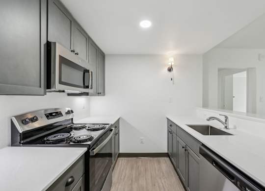 A modern kitchen with a stove top oven and microwave.
