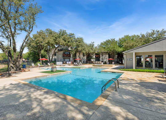 Community Swimming Pool with Pool Furniture at Summit Ridge Apartments located in Arlington, TX.