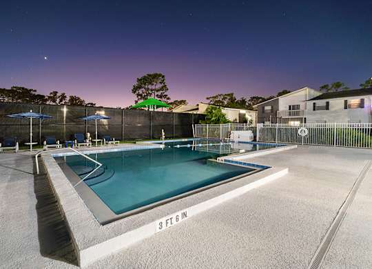 Community Swimming Pool with Pool Furniture at Arbors at Orange Park Apartments located in Orange Park, FL.