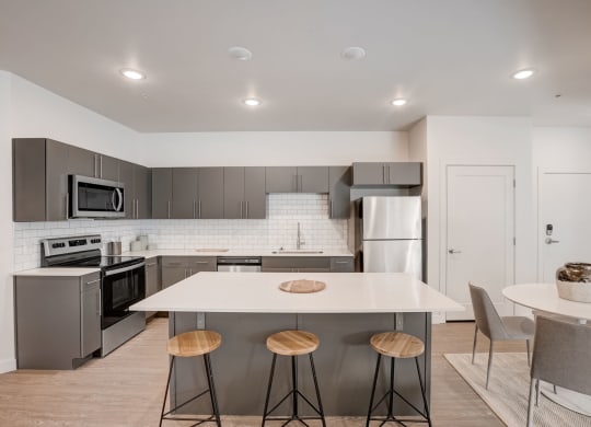a kitchen with a white counter top and stainless steel appliances