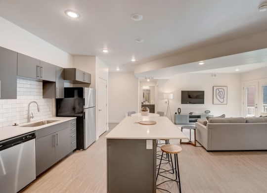 an open kitchen and living room with a white counter top