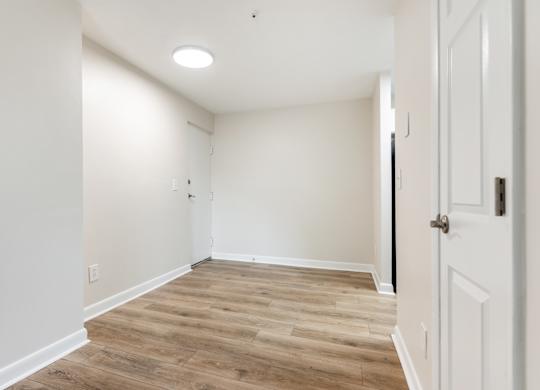 A room with wooden flooring and white walls.