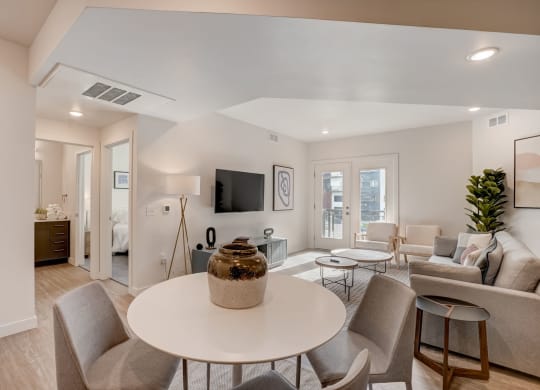 a living room with a round table and chairs and a couch