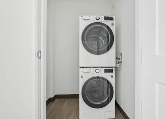 Two white front loading washing machines in a small room.