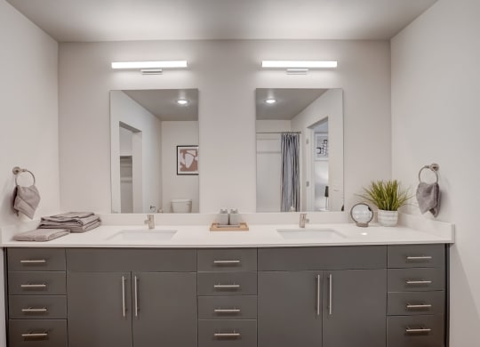 a large bathroom with two sinks and two mirrors