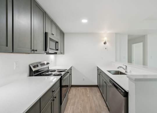 A kitchen with black cabinets and white countertops.