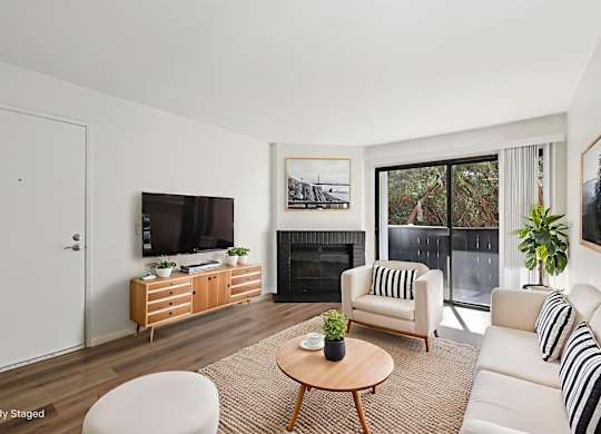 A living room with a fireplace, a white couch, and a coffee table.