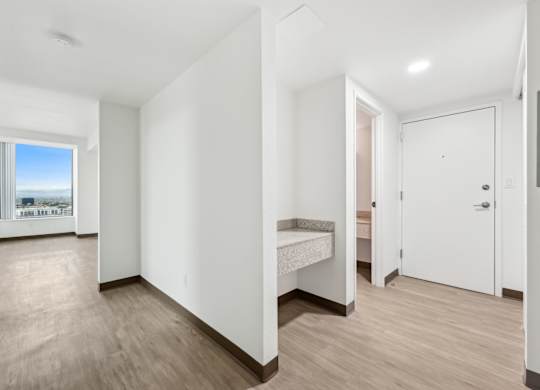 A room with a bed and a window overlooking a cityscape.