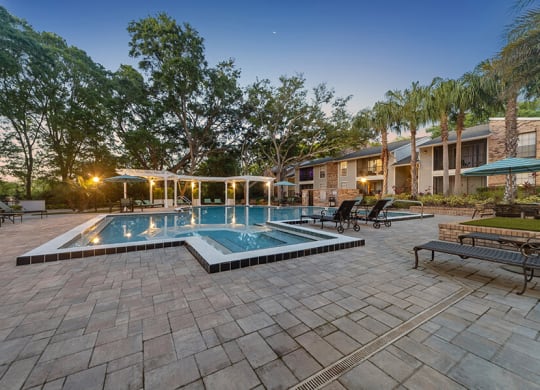 Community Swimming Pool with Pool Furniture at Grand Pavilion Apartments in Tampa, FL.