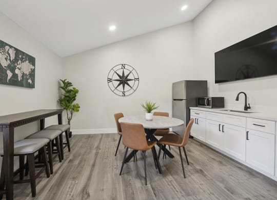 Community Clubhouse with Kitchenette Area and TV at Villages at Metro Center Apartment located in Phoenix, AZ.