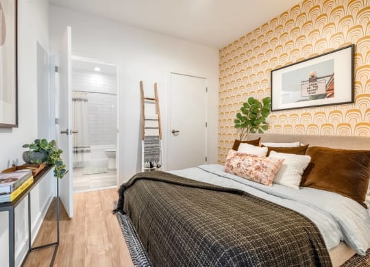 Model bedroom with a bed and attached bathroom