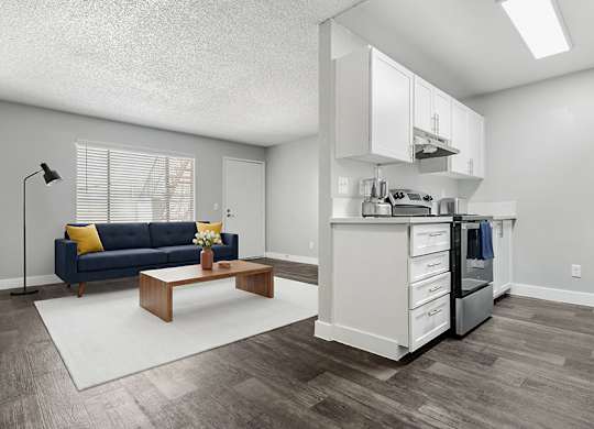 Model Living Room & Kitchen with Wood-Style Flooring at Accent on Rainbow Apartments located in Las Vegas, Nevada.