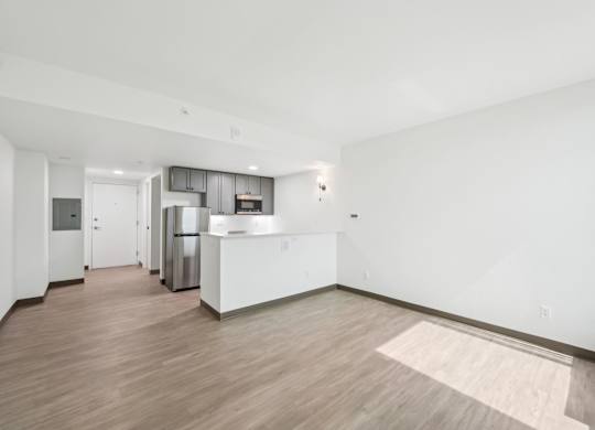 A kitchen with white cabinets and a wooden floor.