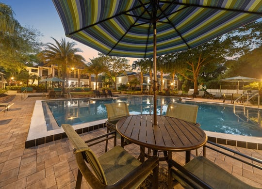 Community Swimming Pool with Pool Furniture at Grand Pavilion Apartments in Tampa, FL.