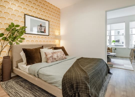Model bedroom with a bed and a yellow wallpaper