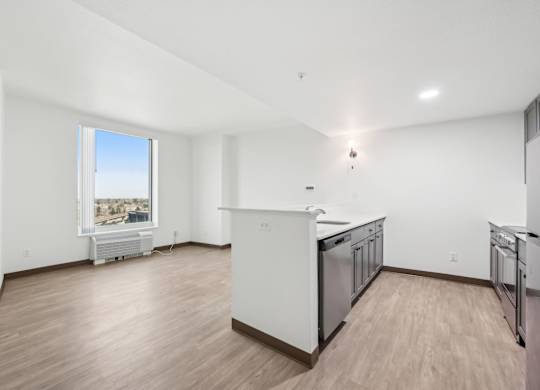 A kitchen with white appliances and wooden floors.