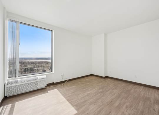 A room with a window overlooking a landscape.