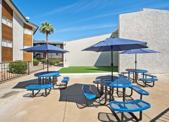 patio with blue tables and chairs and umbrellas