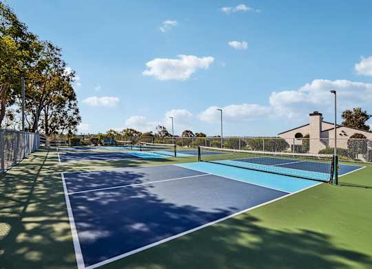 A tennis court with blue and green surface and white lines.