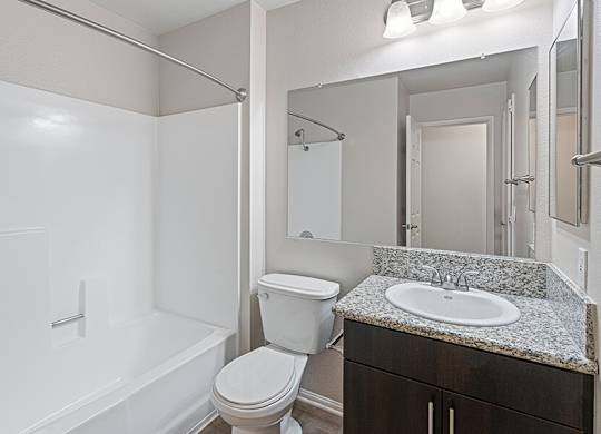 Model Bathroom with Dark Wood Cabinets and Shower/Tub at Santa Fe Ranch Apartments located in Carlsbad, CA.