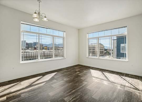 Model Living Room with Wood-Style Flooring and Window Views at Altitude on Fifth Apartments located in Salt Lake City, UT.