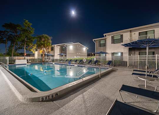 Community Swimming Pool with Pool Furniture at Arbors at Orange Park Apartments located in Orange Park, FL.