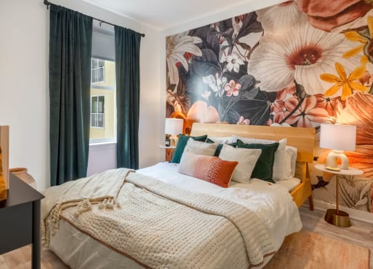 Model bedroom with a bed and a mural on the wall