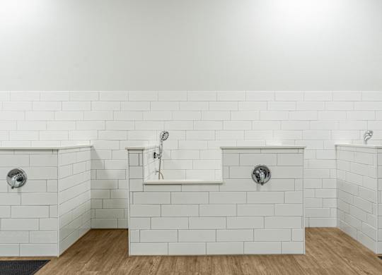 A white tiled bathroom with two sinks and a bathtub.