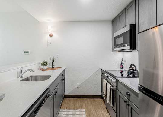 A modern kitchen with stainless steel appliances and a white countertop.