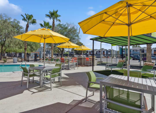the pool at our apartments has tables and chairs with umbrellas