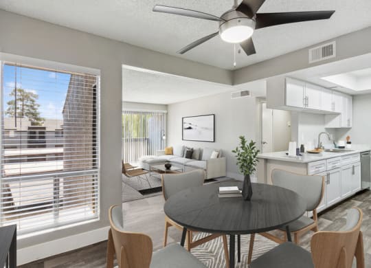 an open living room with a dining room table and a kitchen