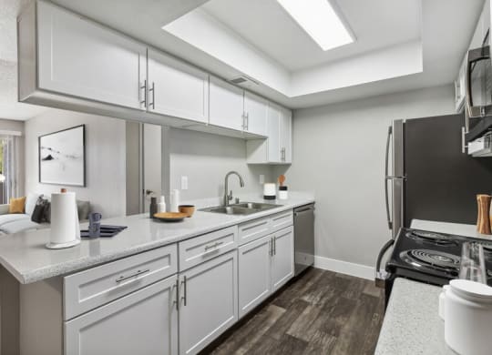 a kitchen with white cabinets and stainless steel appliances