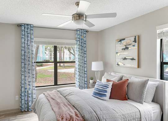 Model Bedroom with Wood-Style Flooring and Window View at Mirage on Kernan Apartments located in Jacksonville, FL.