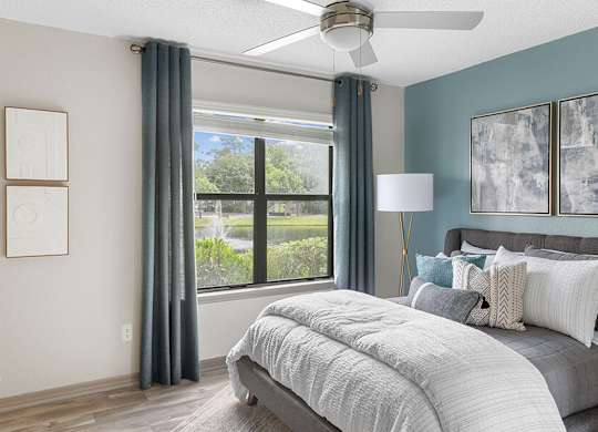 Model Bedroom with Wood-Style Flooring and Window View at Mirage on Kernan Apartments located in Jacksonville, FL.