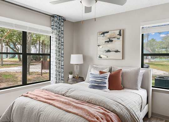 Model Bedroom with Wood-Style Flooring and Window View at Mirage on Kernan Apartments located in Jacksonville, FL.