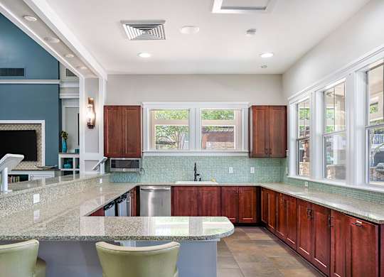 A kitchen with a marble countertop and wooden cabinets.