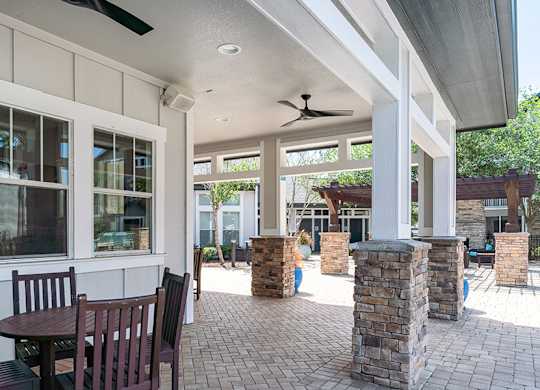 A patio with a table and chairs under a roof.