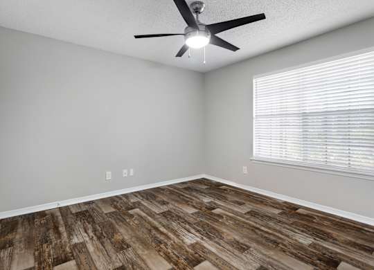 Model bedroom with wooden floors at Caribbean Breeze Apartments in Tampa, FL.