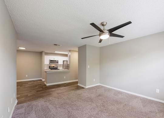 Model living room with ceiling fan and carpet at Fountains at Lee Vista in Orlando, Florida.