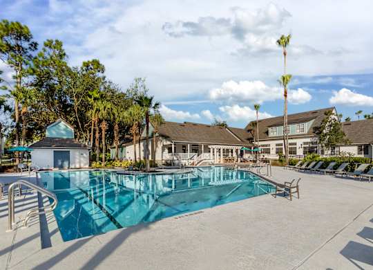 A swimming pool surrounded by trees and buildings.