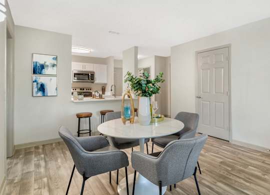 A dining room with a table and chairs.