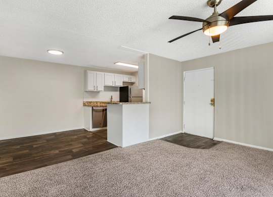 Model living room with ceiling fan, carpeted and at Park at 7200 in Jacksonville, Florida.