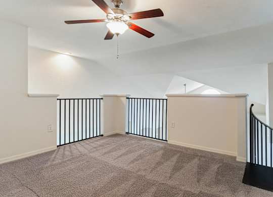 Model second floor landing with carpet and ceiling fan at Veranda at Westchase in Tampa, Florida.