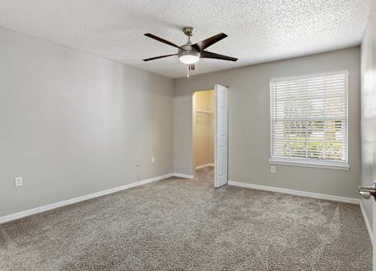 Model bedroom with carpet and and a ceiling fan at Hunters Green in Tampa, Florida.