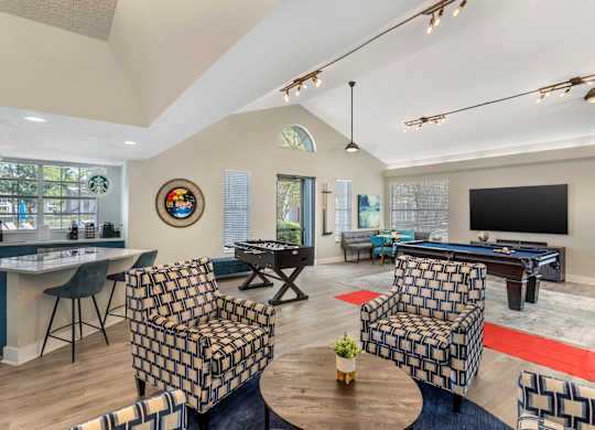 A living room with a pool table and a television.