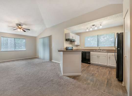 A spacious kitchen with a refrigerator, sink, and cabinets.