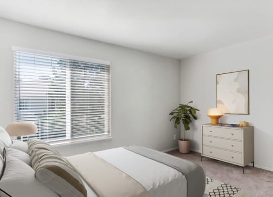 Model bedroom with a large window and a white dresser